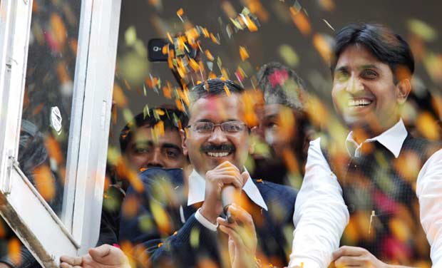 Supporters throw flower petals as Arvind Kejriwal, leader of Aam Aadmi Party, speaks as they celebrate the party's performance in Delhi state Assembly elections, in New Delhi on Sunday - AP Supporters throw flower petals as Arvind Kejriwal, leader of Aam Aadmi Party, speaks as they celebrate the party's performance in Delhi state Assembly elections, in New Delhi on Sunday - AP